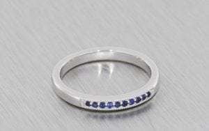 White gold wedding band set with blue sapphires and finished with beaded edges