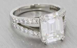 A Dramatic Split Shank Platinum Diamond And Emerald Cut Moissanite Engagement Ring