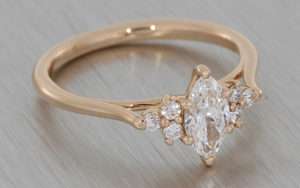 Delicate rose gold engagement ring set with a marquise cut diamond with small round accent diamonds